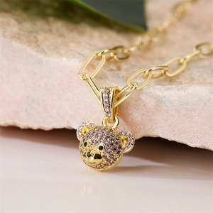 Macro shot of bear pendant necklace with colorful micro-pave zircons on a pink stone
