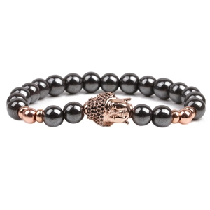 Macro view of hematite stone beads with a rose gold pavé Buddha charm detailing