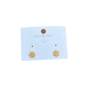 Minimalist gold snowflake stud earrings made of titanium steel on a white gift card