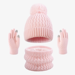 Detailed view of pink winter knit hat, scarf, and touch-screen gloves with pom-poms