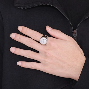 Macro shot of silver stainless steel signet ring with black crackle patterns on model