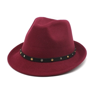 Detailed close-up of wine red fedora hat with gold and silver studded band decoration