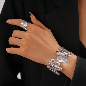 Detailed view of silver textured leaf cuff bracelet and matching ring on model