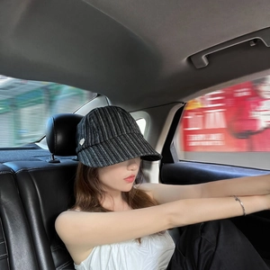 Women's black and white vertical striped bucket hat with a wide brim for sun protection