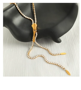 Macro detail of gold adjustable zipper slide necklace with white zircon leaf charms