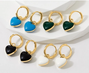 Detail view of heart-shaped enamel drop earrings in blue, green, black and white colors