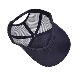Detail of black mesh trucker hat showing snapback closure and interior sweatband structure