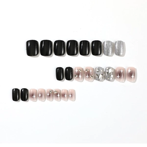 Short square press-on nails set in black, silver glitter, and starburst rhinestones