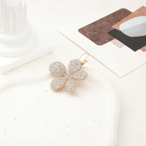 Close-up of golden five-petal flower hair clip with sparkling white rhinestones