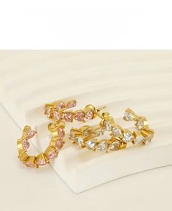 Detail of stainless steel C-shaped hoop earrings with pink and white heart-shaped zircons