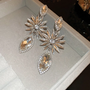 Macro shot of silver floral drop earrings with sparkling rhinestones in a jewelry box