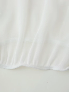 Close-up of white chiffon V-neck blouse showing tiered pleated texture and fine stitching