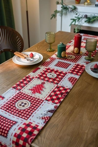 Detail of Christmas table runner featuring red black plaid and festive tree patterns