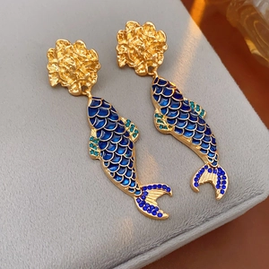 Detailed view of vintage gold-plated flower and blue enamel koi fish drop earrings