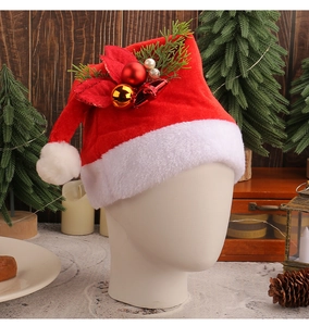 Detail of red plush Christmas hat with pine needles and berries worn by a model