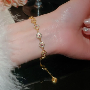 Close-up of 18K gold plated circular bracelet with CZ and red stones