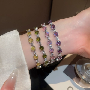 Macro shot of silver tennis bracelets with pink, yellow, purple and green gemstones