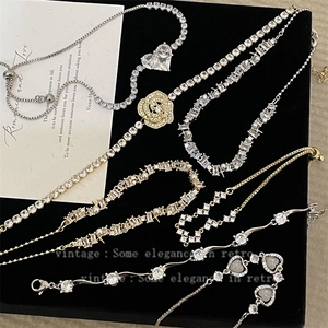 Elegant gold and silver star and heart bracelets with zircon on black velvet background
