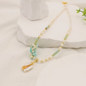 Detail of baroque pearl pendant on long necklace with natural turquoise and stone beads