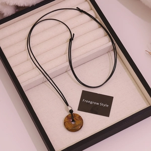 Adjustable necklace with round tiger eye stone pendant in a beige jewelry display box