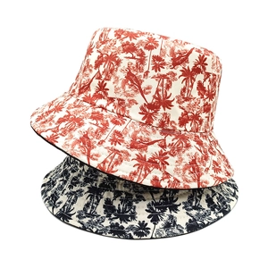 Reversible bucket hat with tropical parrot and palm tree print in red and navy blue