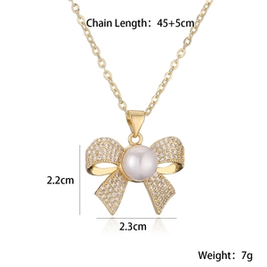 Detail of 18K gold plated bow necklace with white pearl and sparkling crystals