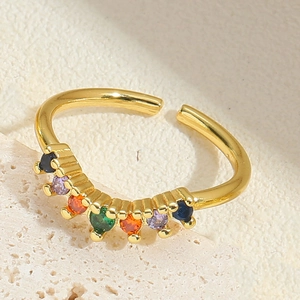 Macro shot of gold adjustable ring featuring colorful round inlaid gemstones on stone