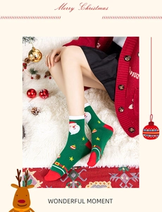Close-up of green festive Christmas socks featuring Santa patterns on a plush rug