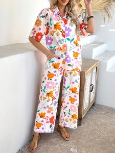 Close-up of bohemian set showing colorful floral print on short sleeve shirt and wide pants