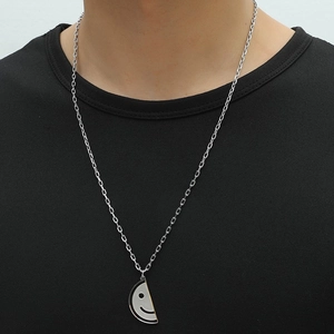 Detail of silver ghost smiley face pendant necklace on model showing its dual-tone finish