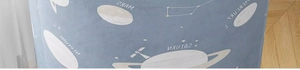 Close-up of solar system print fabric showing Mars and Saturn names on blue textile