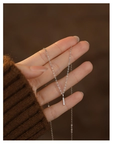 Close-up of minimalist S925 silver necklace with rectangular diamond bar pendant