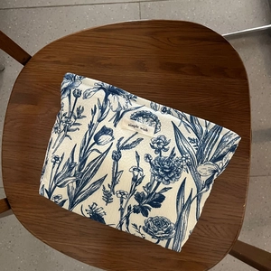 Blue Toile de Jouy floral canvas cosmetic bag with 'simple wish' label on wooden chair