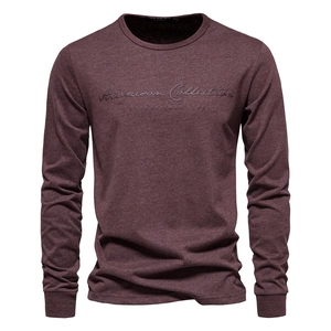 Detail of burgundy long sleeve T-shirt with Acapeson Collection embroidery on the chest