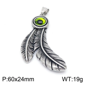 Macro shot of silver feather pendant with green eye stone detailing stainless steel jewelry