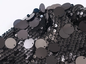 Macro detail of high-quality black sequins on mesh fabric for luxury women's long sleeve shirts