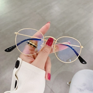 Close-up of gold metal round eyeglass frames with blue light blocking lenses