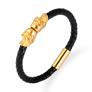 Braided black leather bracelet with double golden skulls and magnetic metal clasp