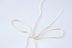 Close-up of beige fabric strap with yellow contrast stitching tied in a bow