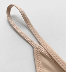 Macro view of precise Z-shape reinforced stitching on nude seamless ice silk thong fabric