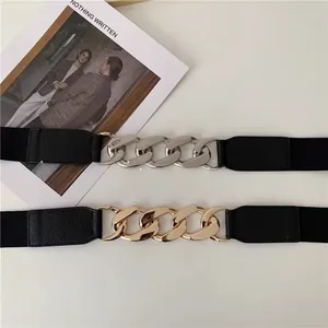 Detailed view of punk style elastic belts with gold and silver chunky metal chains