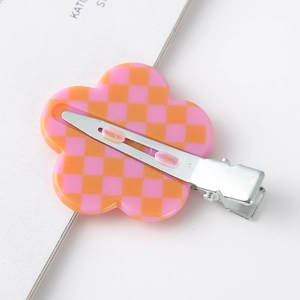 Detailed back view of pink and orange checkerboard flower hair clip with silver metal grip
