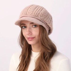 Detalle del gorro de punto rosa con diseño de trenzas y textura suave de lana