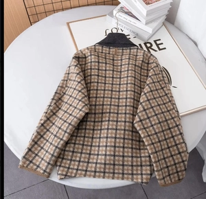 Gilet en maille à carreaux vintage avec revers sur une table blanche décorée