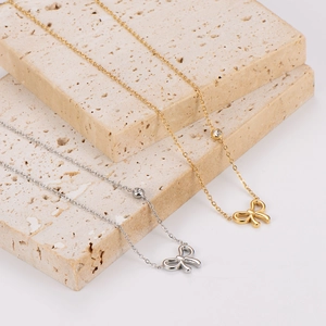 Elegant gold and silver bow necklaces with sparkling stones on natural stone blocks