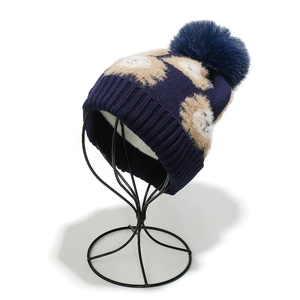 Détail d'un bonnet d'hiver en laine bleu marine avec pois en peluche et un pompon