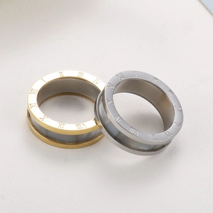 Detail view of gold and silver stainless steel rings with Roman numeral engravings