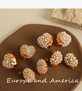 Detail of vintage 18K gold plated earrings with heart and oval pearl inlay designs