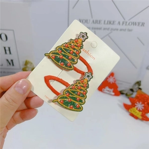 Sparkly green Christmas tree hair clips with red dots on a festive card, set of two