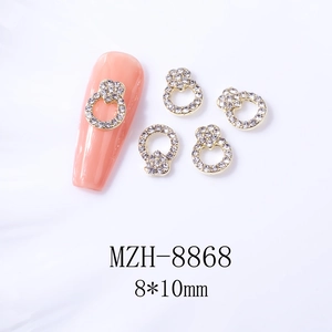 Détail de bijoux d'ongles dorés 8x10mm avec strass montrant l'effet sur ongles roses